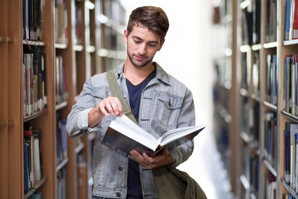 Homem lendo um livro na biblioteca