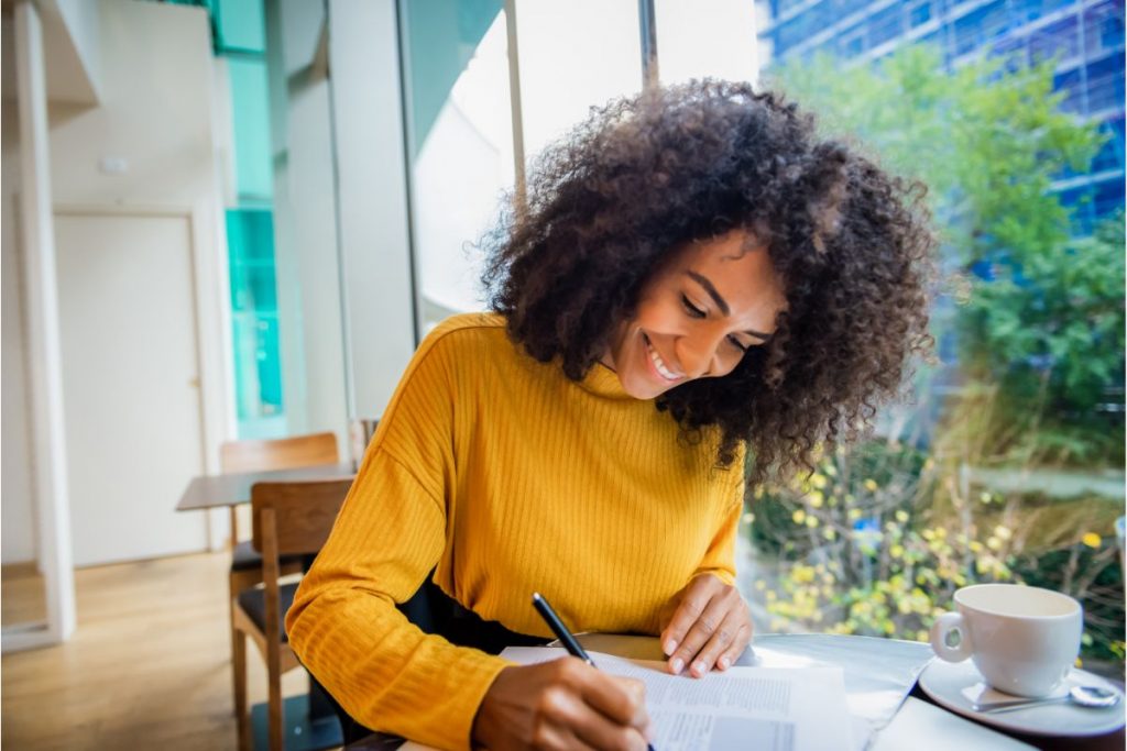 Mulher estudando e fazendo anotações
