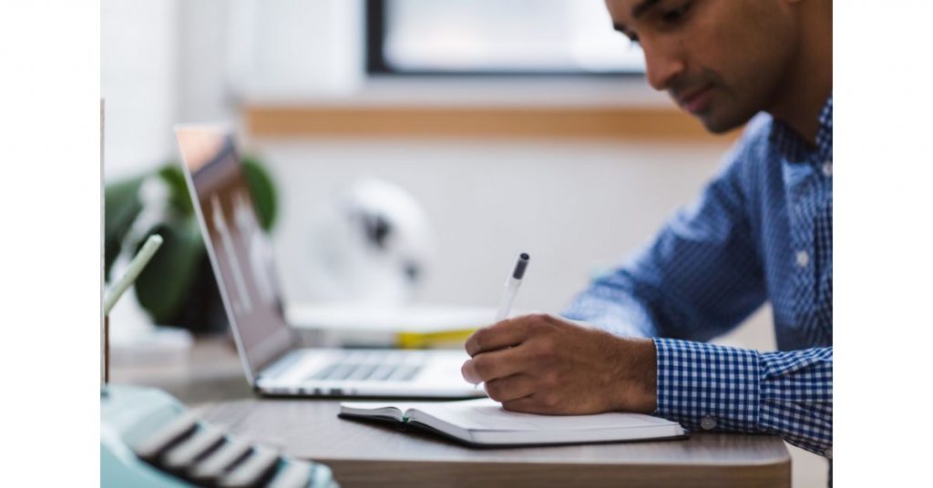 Homem estudando e fazendo anotações
